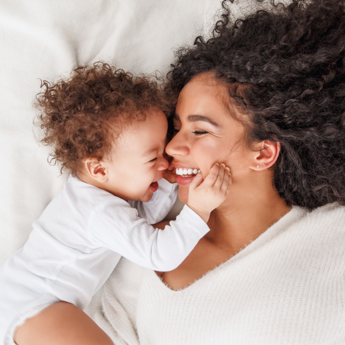 Mother and baby laughing together after a dry, restful night