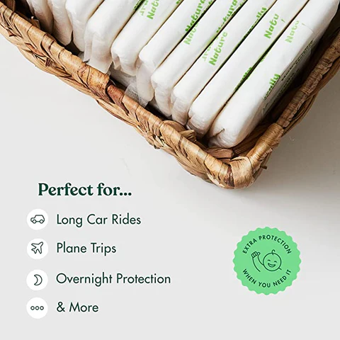 Your secret to more sleep — Naturally Nature overnight booster pads in a woven basket with baby blanket and pacifier